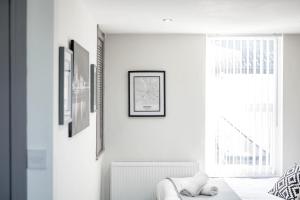 a white room with a bed and a window at Burnand House - Air Host & Stay - Sleeps 9 in Liverpool