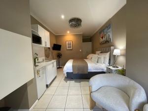 a hotel room with a bed and two chairs at DOMIN LUXURY SUITES in Cape Town +26 photos