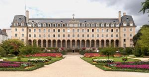 a large building with a garden in front of it at Hotel Mercure Rennes Cesson in Cesson-Sévigné