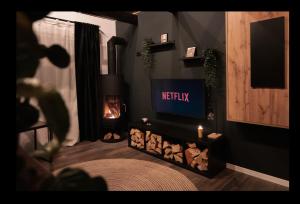 a living room with a tv and a fireplace at TheAttic in Corbeni