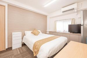 a hotel room with a bed and a television at 鵜の木民宿101号室鵜の木駅から徒歩4分とても便利の場所 in Tokyo