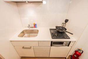 a small kitchen with a sink and a stove at 鵜の木民宿101号室鵜の木駅から徒歩4分とても便利の場所 in Tokyo