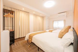 a bedroom with two beds and a window at 鵜の木民宿101号室鵜の木駅から徒歩4分とても便利の場所 in Tokyo
