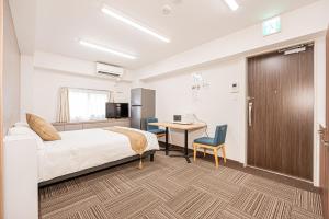 a hotel room with a bed and a desk with a computer at 鵜の木民宿101号室鵜の木駅から徒歩4分とても便利の場所 in Tokyo