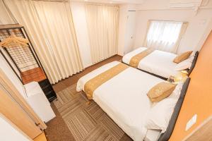 a hotel room with two beds and a window at 鵜の木民宿101号室鵜の木駅から徒歩4分とても便利の場所 in Tokyo