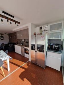 a kitchen with a large stainless steel refrigerator at La Chrysalide - Classé 3 étoiles - 4 pers - Port du Cap d'agde - Plage - Clim - Wifi - Histoire de clés in Cap d'Agde