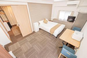 a hotel room with a bed and a desk and a table at 鵜の木民宿101号室鵜の木駅から徒歩4分とても便利の場所 in Tokyo