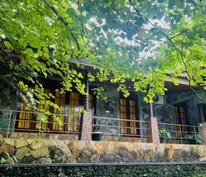 a stone house with yellow windows and a fence at Sisiliyana Stone Resort in Gonapola