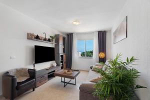 a living room with a couch and a flat screen tv at Apartamento Rincon Tropical in Candelaria
