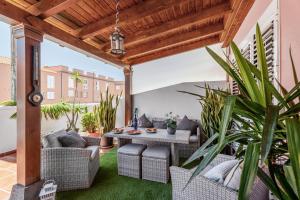 カンデラリアにあるCasa Brisas De Candelariaの籐家具と植物のある屋外パティオ