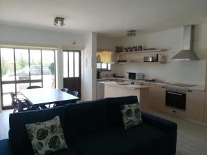 a living room with a couch and a table and a kitchen at Baleal Time Out in Ferrel