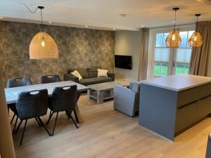 a kitchen and living room with a table and chairs at State Klaver Vier in Hollum
