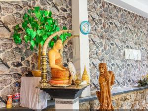 a table with statues and a clock on a wall at Sisiliyana Stone Resort in Gonapola