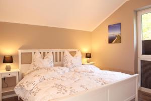 una camera da letto con un letto bianco e una finestra di Villa Thormarcon am Plauer See für 18 Gäste, Sauna, Pool a Lenz