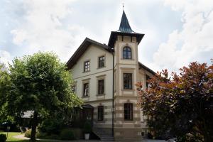 a church with a steeple on top of a building at Villa Fantasia Budget Boutique Hotel in Füssen