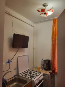 eine Küche mit einem Herd und einem TV an der Wand in der Unterkunft Amy&Domy in Iscroni