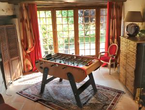 a room with a foosball table in front of a window at Maison confortable à Saint-Georges-sur-Baulche avec terrasse et jardin in Saint-Georges-sur-Baulche