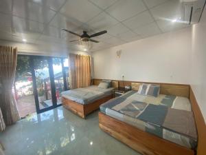 una camera da letto con due letti e un ventilatore a soffitto di Homestay Phú Thường Beach a Phước Ðổng (1)