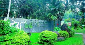 a sign in a park with green grass and trees at Sisiliyana Stone Resort in Gonapola