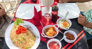 a table with plates of food and drinks on it at Sisiliyana Stone Resort in Gonapola