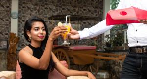 a woman sitting next to a man holding a drink at Sisiliyana Stone Resort in Gonapola