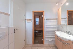 a white bathroom with a sink and a mirror at Gartendeck 501 in Rechlin