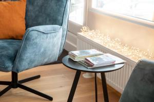 a blue chair and a table with books on it at Ferienwohnung Penthouse Feldberg in Feldberg +37 photos