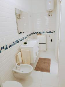 a white bathroom with a toilet and a sink at La casetta della luna in Castro di Lecce +9 photos