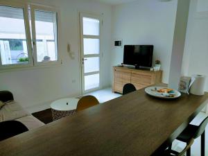 a living room with a table and a television at La casetta della luna in Castro di Lecce