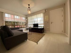 a living room with a couch and a table and a door at Housingcoruña Apartamento Playa Miño 01 in Miño