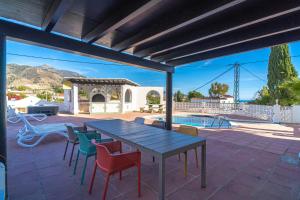 a patio with a table and chairs and a pool at Villa Mauri Private Pool by Casasol in Nerja