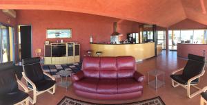 a living room with a red leather couch and chairs at The Penthouse in Port Fairy