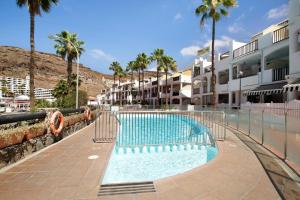 una piscina frente a un edificio con palmeras en Paradise Sea, en Mogán