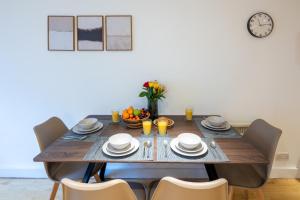 a dining room table with chairs and a clock on the wall at Central Flat-2Bedrooms-2Bath-By FabAccommodation in Bristol