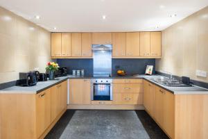a kitchen with wooden cabinets and a stove top oven at Central Flat-2Bedrooms-2Bath-By FabAccommodation in Bristol