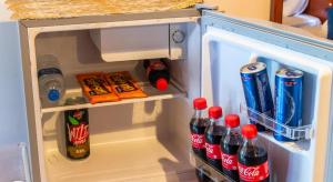 an open refrigerator filled with drinks and sodas at Sisiliyana Stone Resort in Gonapola