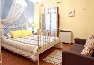 ロブレディージョ・デ・ガタにあるCharming House in Robledillo de Gata with Fireplace and Terraceの天蓋付きベッドとソファのある寝室