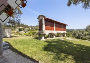 a house in a field with a grass yard at Quinta de Ramil in Vieira do Minho