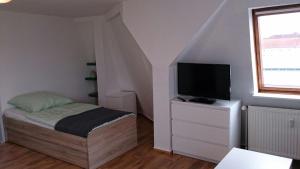 a small bedroom with a bed and a television at Rickmersstraße 61 Bremerhaven in Bremerhaven