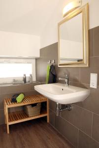 un bagno con un lavandino bianco e uno specchio di Bergtraum Braunlage im Harz, 17 Gäste, Sauna, Hottub-Pool a Braunlage Altre 23 foto