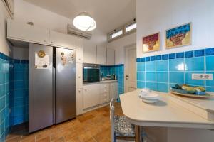 cocina con paredes de azulejos azules y nevera en Villa Grace Home Holiday 50 mt from the sea, en Fort Village 24 fotos más