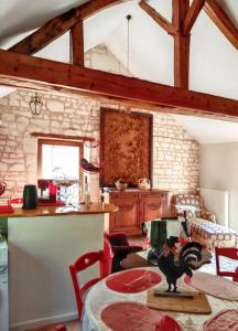 a kitchen with a table with a rooster on a table at Maison charmante à Courchamps avec vue sur jardin in Courchamps