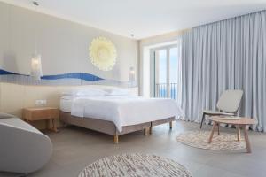 图彻皮Bluesun Hotel Jadran的一间带床和椅子的白色卧室