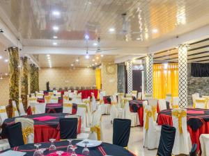 a banquet hall with white and red tables and chairs at Sisiliyana Stone Resort in Gonapola