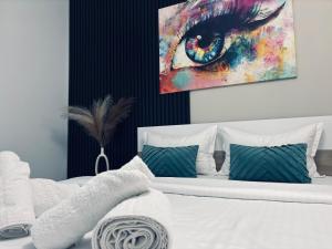 奥拉迪亚Adam Residence的卧室里有一张床，墙上挂着一幅画