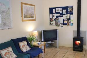 a living room with a couch and a television at Palace Farm Courtyard and Granary Rooms in Doddington