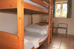 a bedroom with two bunk beds with white sheets at Palace Farm Courtyard and Granary Rooms in Doddington