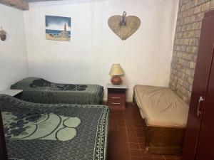 Habitación pequeña con 2 camas y un corazón en la pared. en Angelita sobre playa, en Aguas Dulces