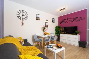 un salon avec un mur aux accents violets dans l'établissement Beskid Apartment 4 z widokiem na góry, Sauna, Jacuzzi, à Szczyrk