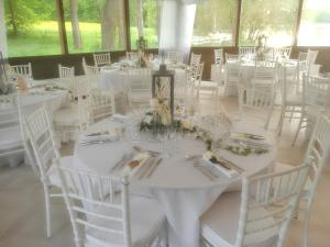 a room full of tables and chairs with white tablecloths at Villa spacieuse et conviviale à Courtenay avec jardin clôturé in Courtenay